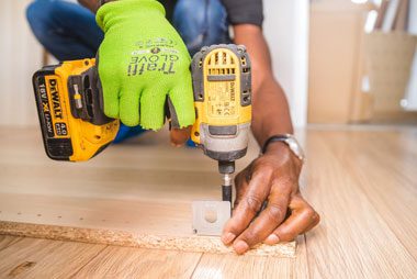 Tradesman fixing a board with a cordless drill